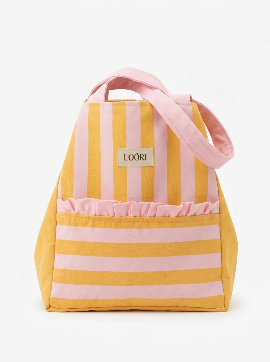 Detalle del volante rosa y la etiqueta LOÖRI del bolso CAPRI