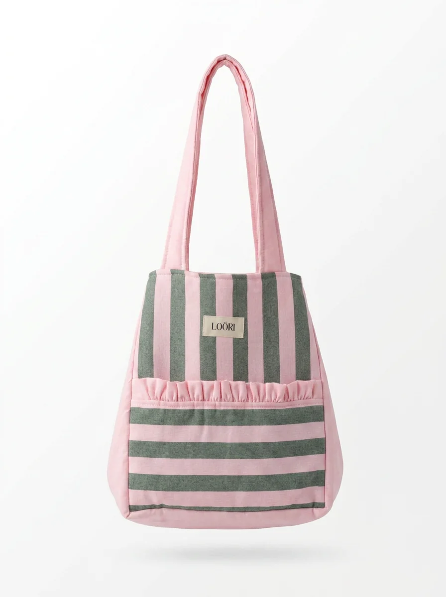 Bolso LOÖRI SERENA de rayas rosas y verdes con asas rosas sobre fondo blanco